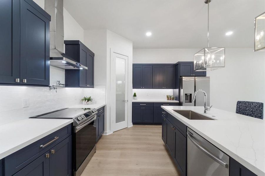 Quartz countertops, Midnight blue soft close cabinets, stainless steel appliances, Undermount cabinet lighting, walk in pantry, pre wired for home security, entertainment, internet, ceiling accent lighting.