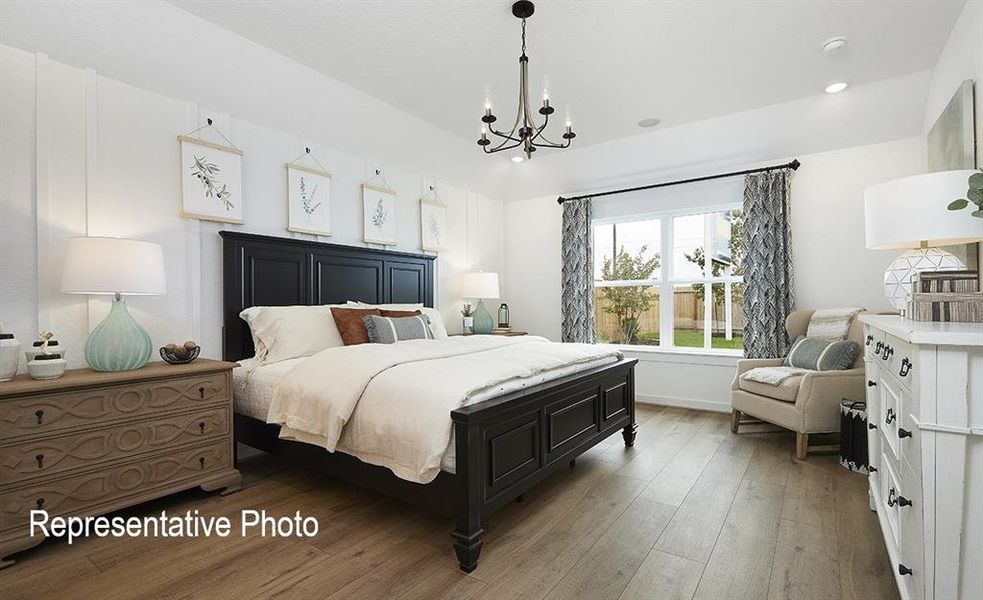 Bedroom with an inviting chandelier and hardwood / wood-style floors