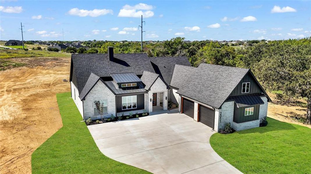 Modern farmhouse style home with a garage and a front yard