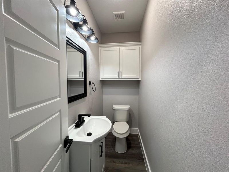 Bathroom with hardwood / wood-style floors, toilet, and vanity