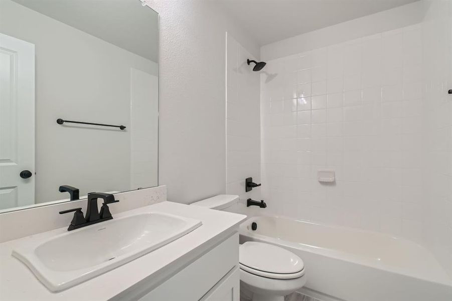 Full bathroom with vanity, toilet, and tiled shower / bath