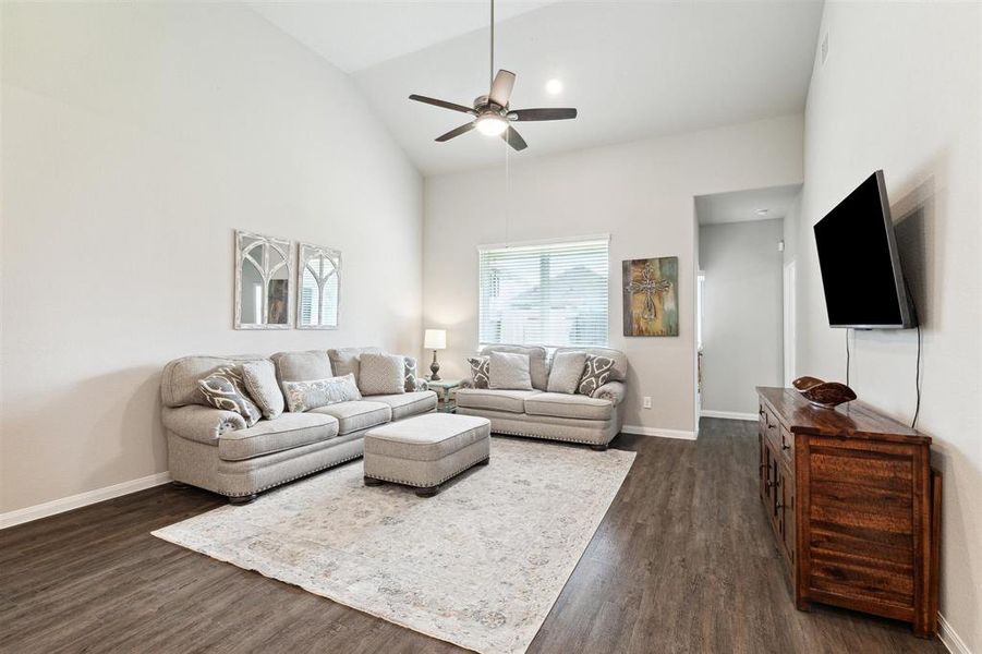 Vinyl plank flooring, ceiling fan and blinds complete this beautiful space. The principal bedroom room is off to the right at the back of this photo.