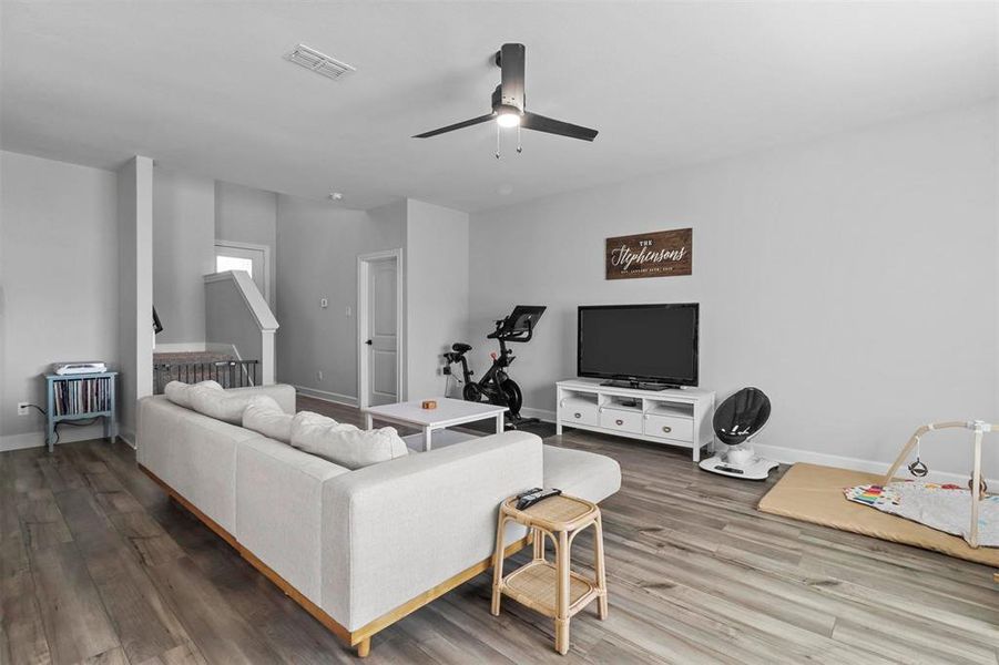 Living room featuring hardwood / wood-style flooring and ceiling fan