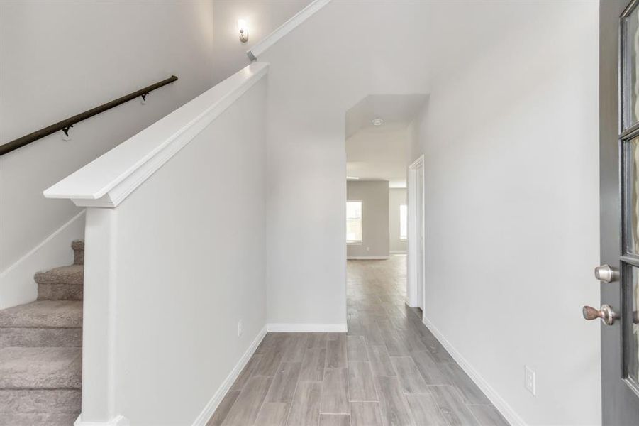 Step inside and be greeted by a welcoming entryway that sets the tone for the rest of the home. The light, neutral color palette paired with sleek flooring creates a clean and inviting atmosphere. This space effortlessly connects the upstairs and living areas, offering a seamless flow throughout the home. It's the perfect introduction to the modern yet comfortable design that defines this property. **This image is from another Saratoga Home with similar floor plan and finishes, not the June floorplan.**