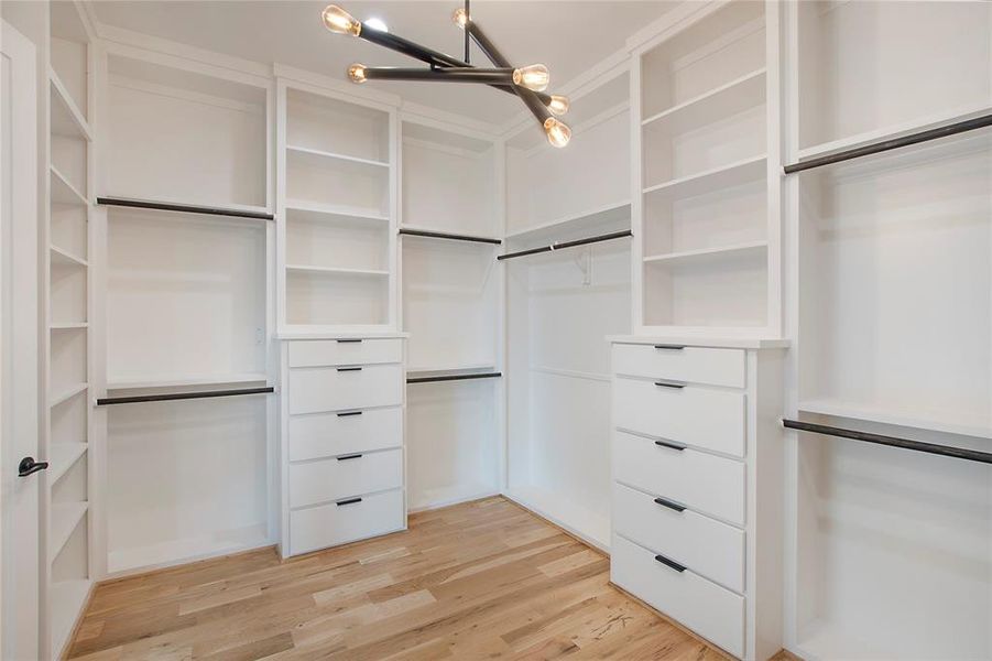 Walk in closet featuring a chandelier and light hardwood / wood-style floors