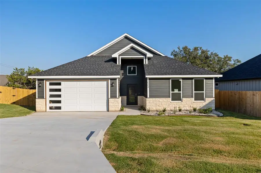 View of front facade with a front lawn and a garage