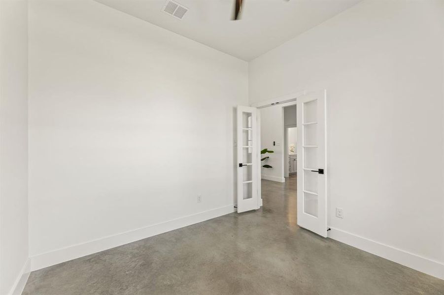 Unfurnished room featuring concrete floors and french doors