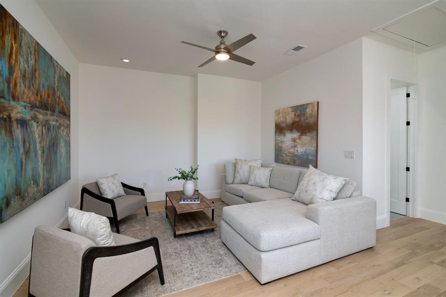 Living room with ceiling fan and light hardwood / wood-style floors