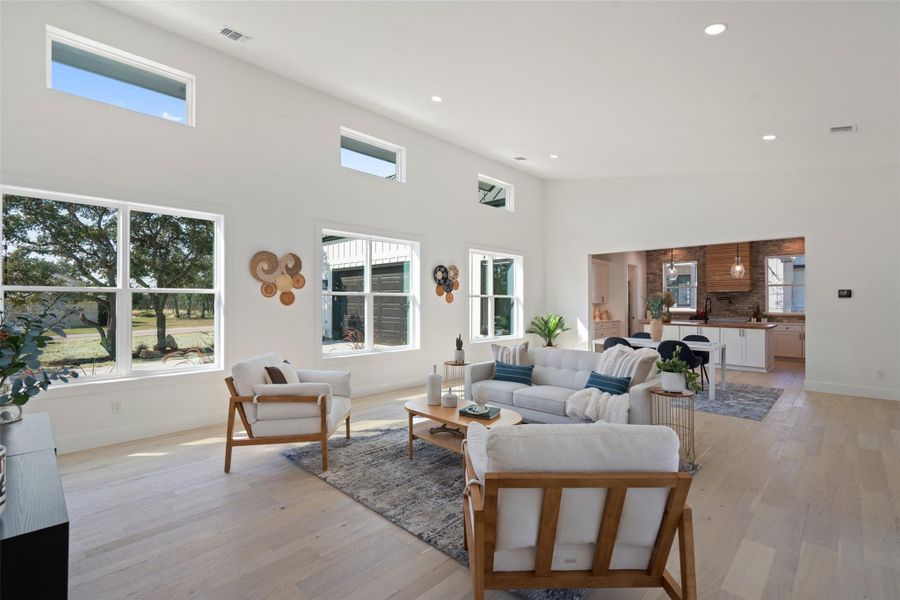 Open-concept floorplan with soaring ceilings, floor-to-ceiling slider windows, and abundant natural light.