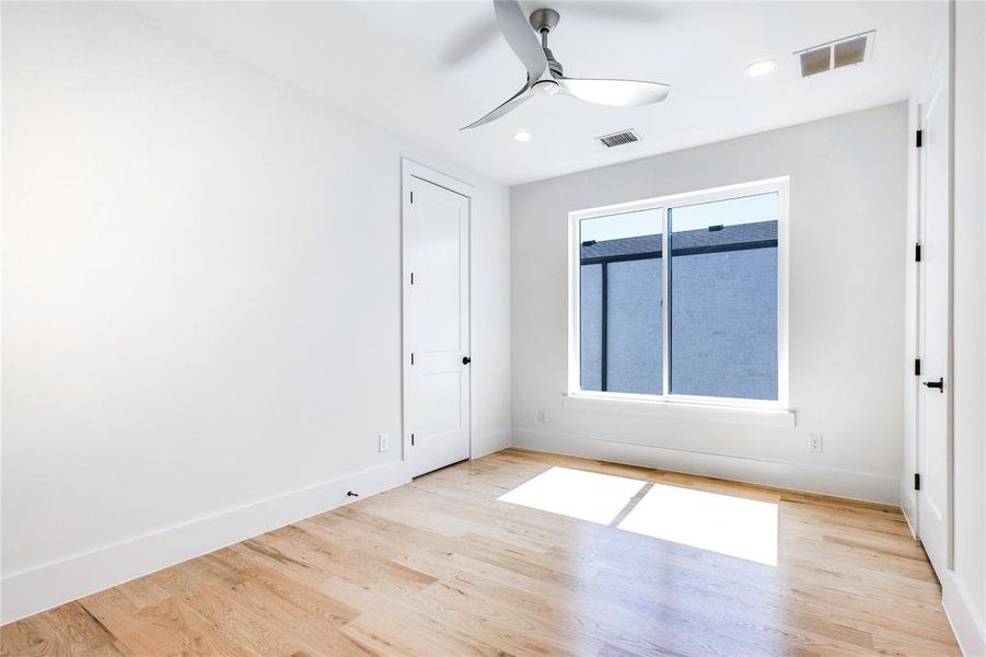 Unfurnished room with light wood-type flooring, ceiling fan, and a healthy amount of sunlight