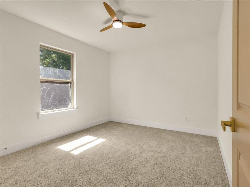 Carpeted empty room featuring ceiling fan