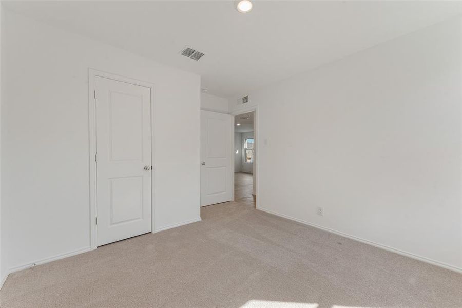 Unfurnished bedroom with light colored carpet