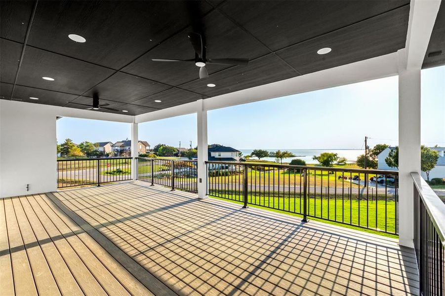 Wooden terrace with ceiling fan, a yard, and a water view