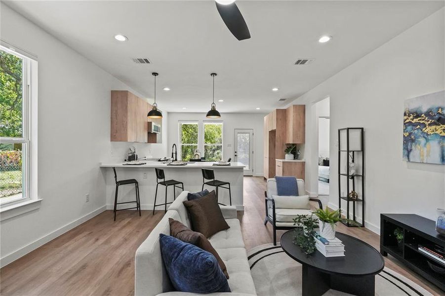 Living room with light hardwood / wood-style floors, ceiling fan, and sink