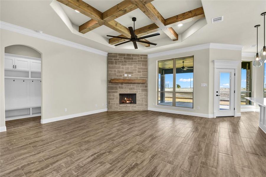 Unfurnished living room with crown molding, coffered ceiling, beamed ceiling, and hardwood / wood-style floors