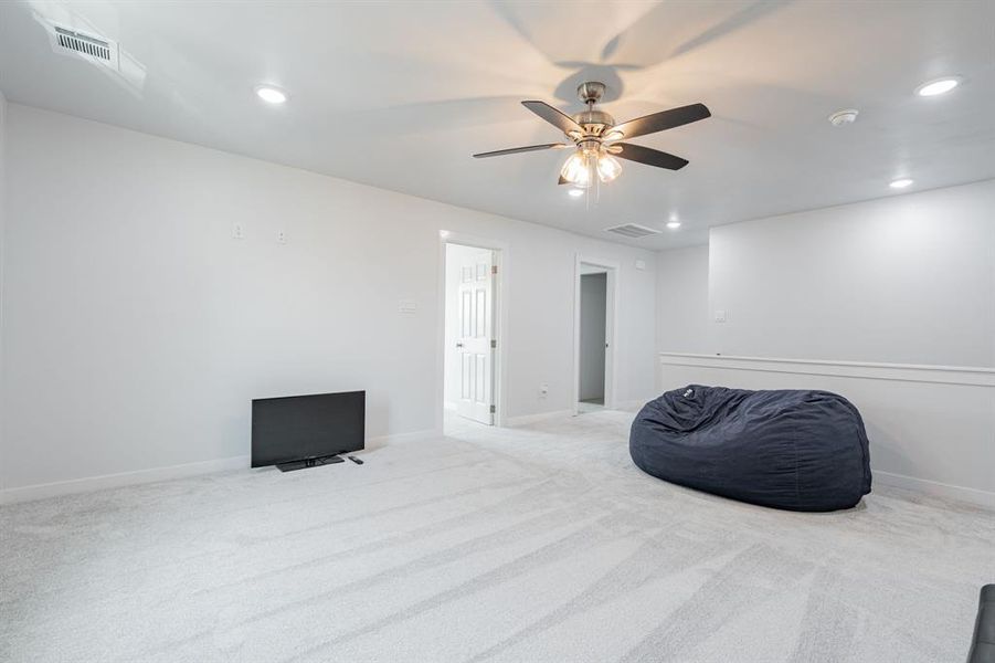 Sitting room featuring ceiling fan and carpet