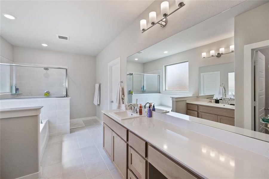 Bathroom featuring vanity, tile patterned floors, and separate shower and tub