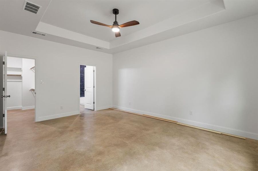 Unfurnished room featuring a tray ceiling and ceiling fan