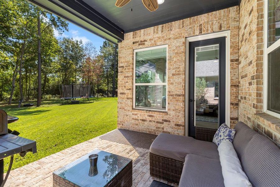 Relax on the brick patio with fan and great lighting. Perfect for the fall evenings as you overlook the tree grove behind you in your private backyard!