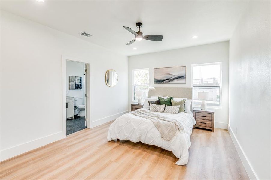 Bedroom featuring ceiling fan, hardwood / wood-style flooring, and ensuite bathroom