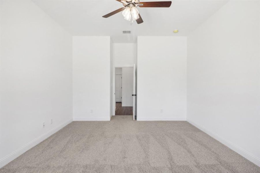 Unfurnished room with ceiling fan and light colored carpet