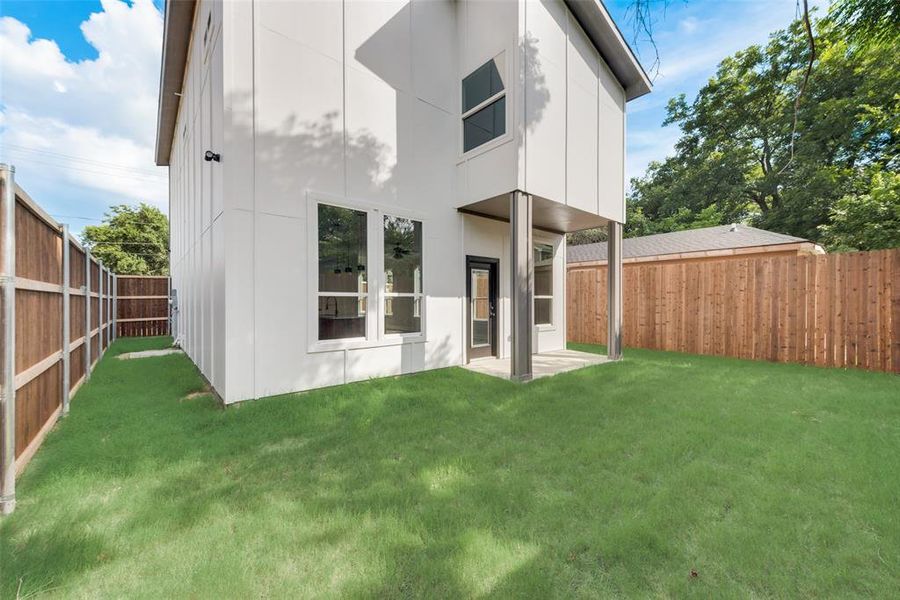 Rear view of house featuring a lawn