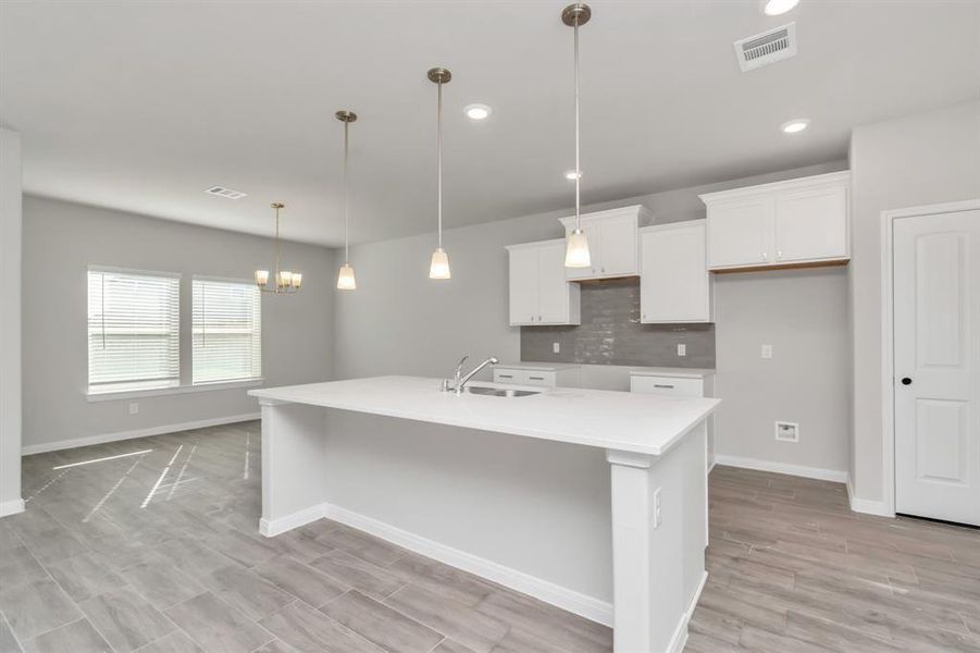 Enjoy the convenience and style of this expansive kitchen, where modern design meets practical functionality. The large island is perfect for meal prep and casual dining, while the ample cabinetry and counter space ensure everything has its place. The adjacent dining area, bathed in natural light, completes this ideal setup for both everyday living and entertaining.