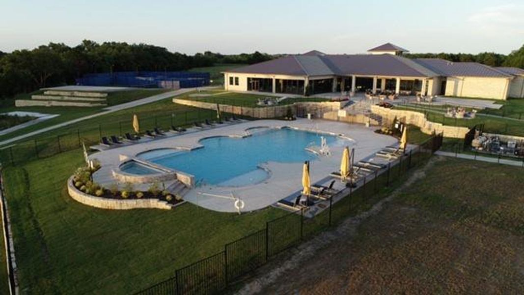 View of swimming pool with a hot tub, a patio area, and a lawn