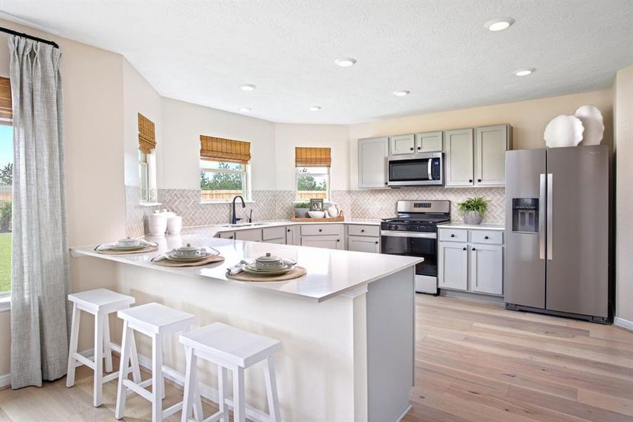 This kitchen is by far any chef’s dream! This spacious kitchen features high ceilings, dark stained cabinets, gorgeous countertops, SS appliances, modern tile backsplash, recessed lighting, extended countertop for breakfast bar, and a walk-in pantry all overlooking your huge family room.