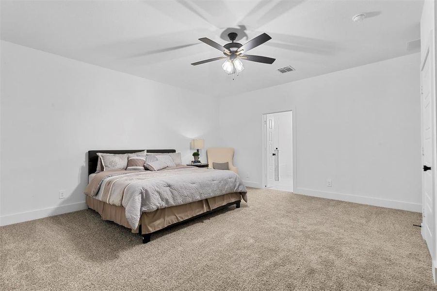 Carpeted bedroom featuring ceiling fan