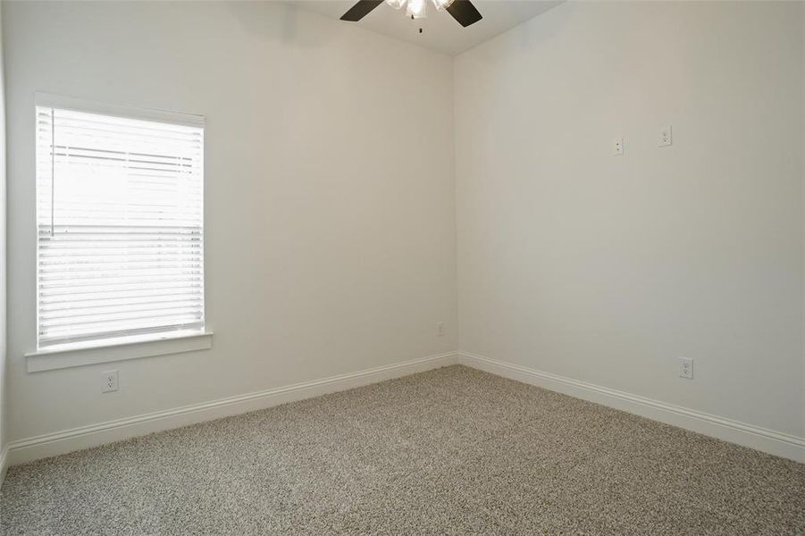 Carpeted empty room featuring ceiling fan