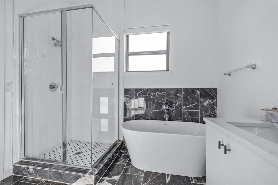 Primary Bathroom featuring vanity and separate shower and tub