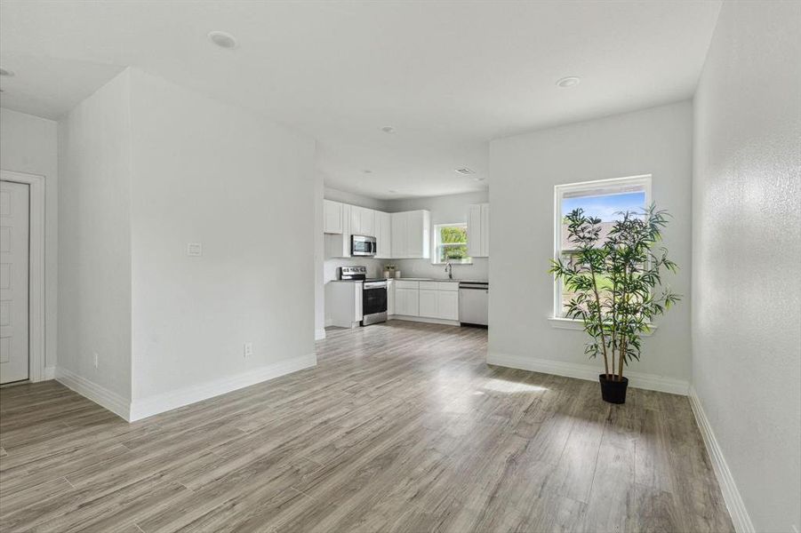 Unfurnished living room featuring light hardwood / wood-style floors and sink