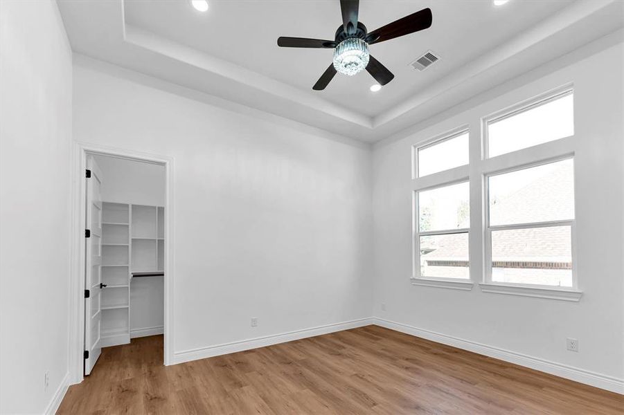 The third bedroom with high, step ceiling, 3 switch LED ceiling fan, walk-in closet and plenty of natural light.