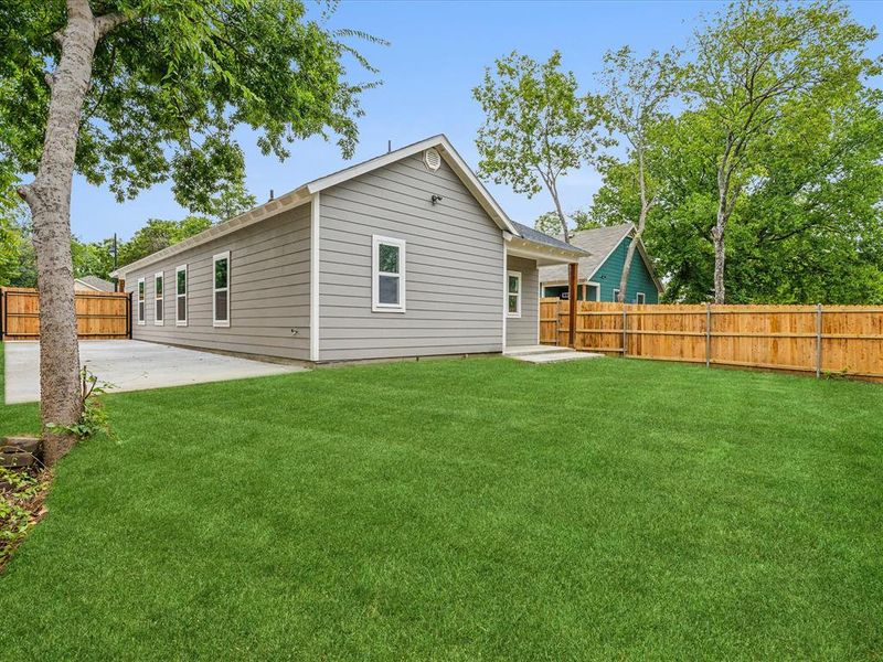 Rear view of property featuring a lawn and a patio