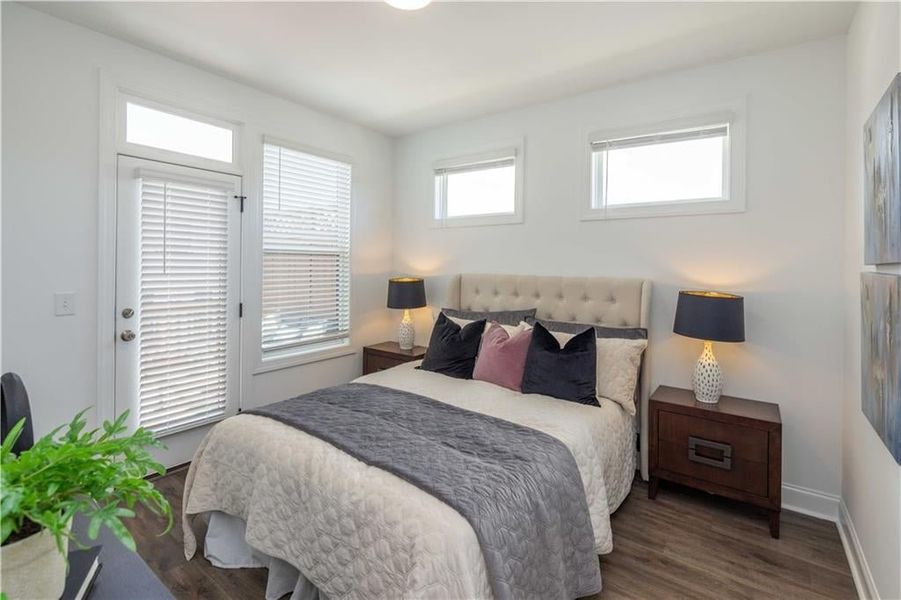 Bedroom with dark hardwood / wood-style floors with an opening to the upper wooden deck not the actual unit