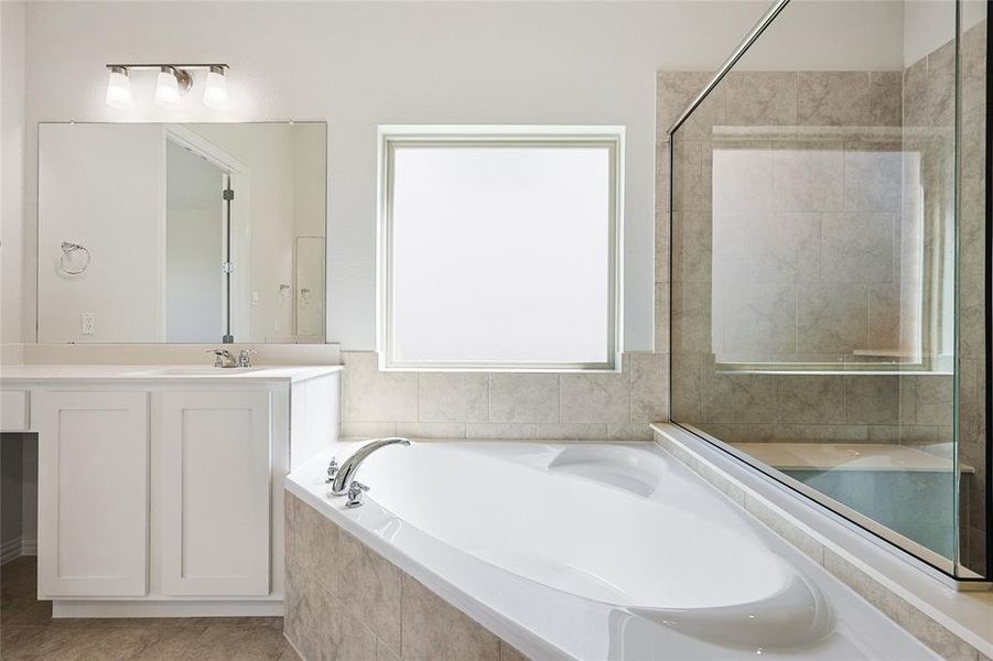 Bathroom with vanity, plus walk in shower, and tile patterned flooring