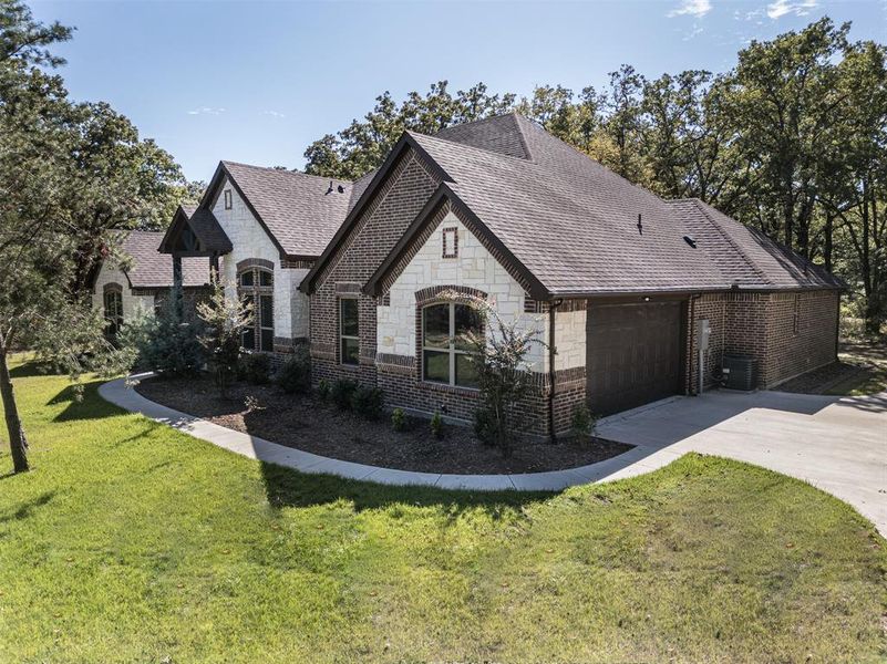 View of property exterior with a lawn, cooling unit, and a garage