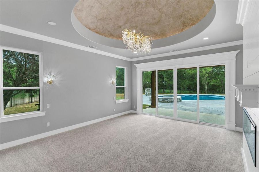 Kitchen featuring appliances with stainless steel finishes, decorative light fixtures, a notable chandelier, tasteful backsplash, and custom exhaust hood