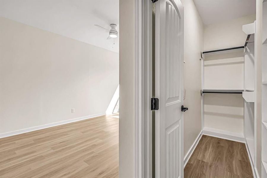 Primary closet with hanging rods and built in shelves.