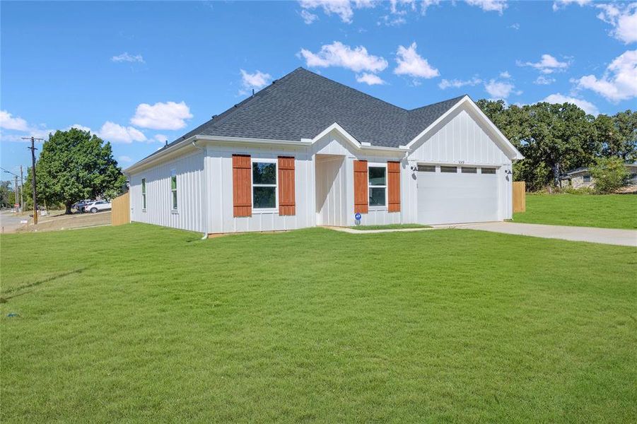 Modern farmhouse style home featuring a garage and a front lawn