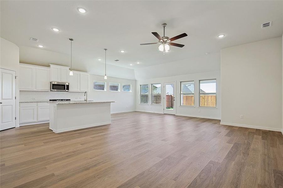 Unfurnished living room featuring sink, light wood-type flooring, and ceiling fan