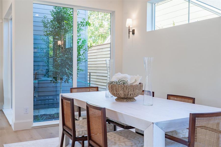 Dining room with light hardwood / wood-style floors and a wealth of natural light