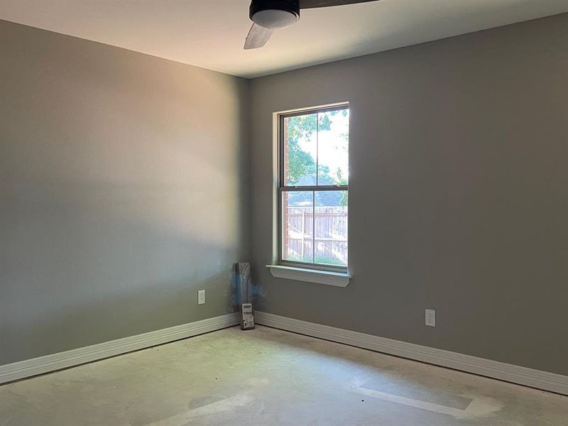 Spare room featuring concrete floors and ceiling fan