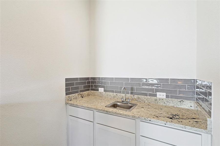 Bathroom featuring vanity and backsplash