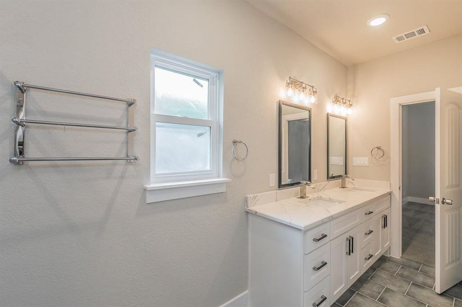 Primary Bathroom featuring tile flooring and double vanity