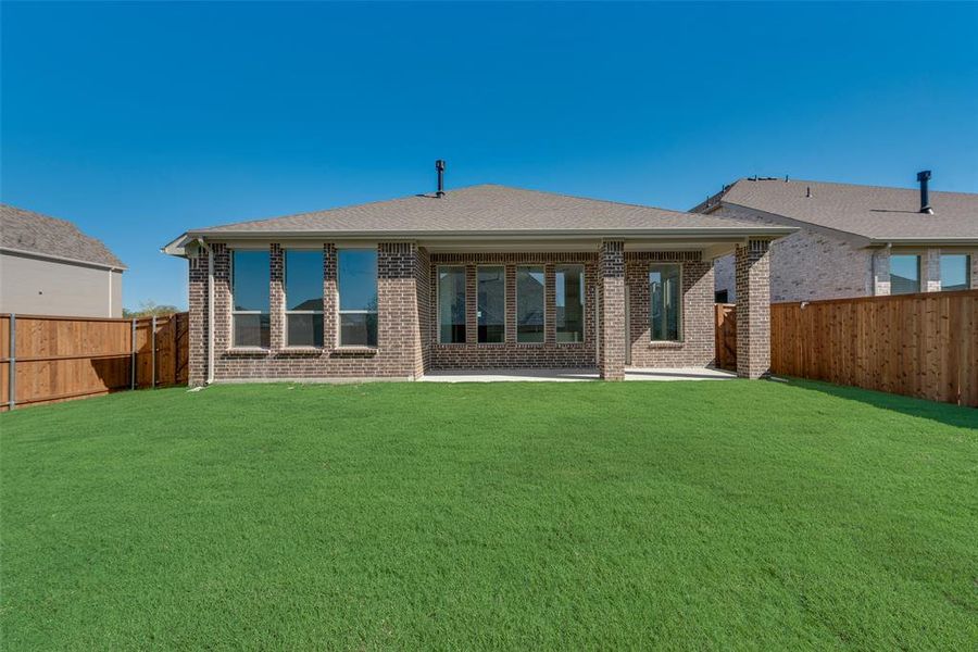 Rear view of property with a patio and a lawn