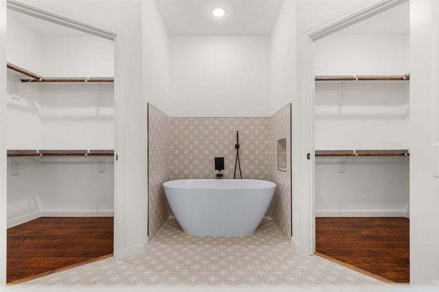 Bathroom featuring a bathing tub, tile patterned flooring, and tile walls