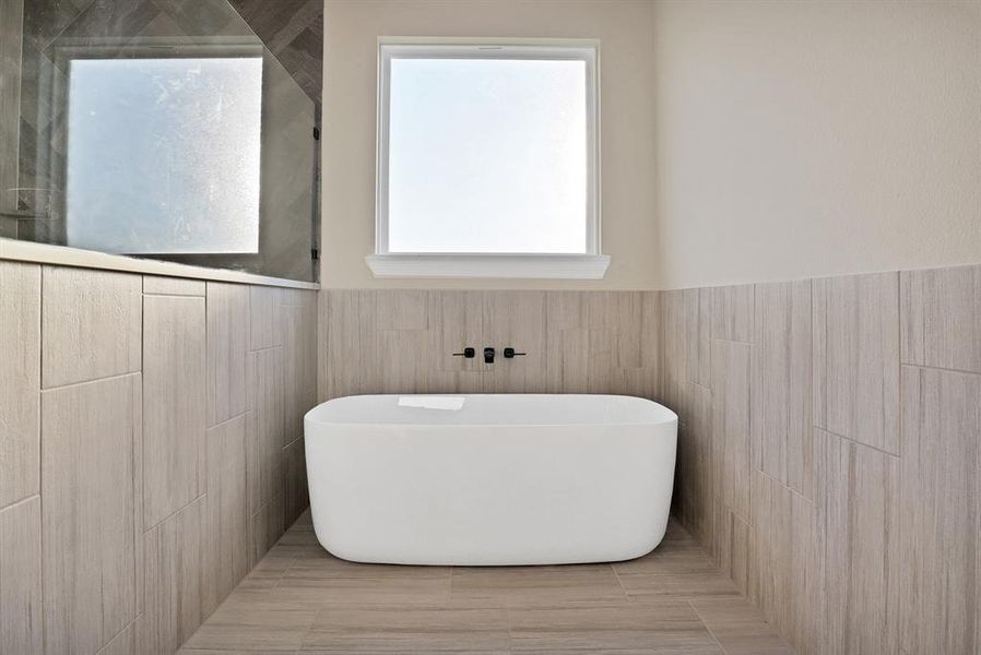 Bathroom with tile walls and a bathing tub