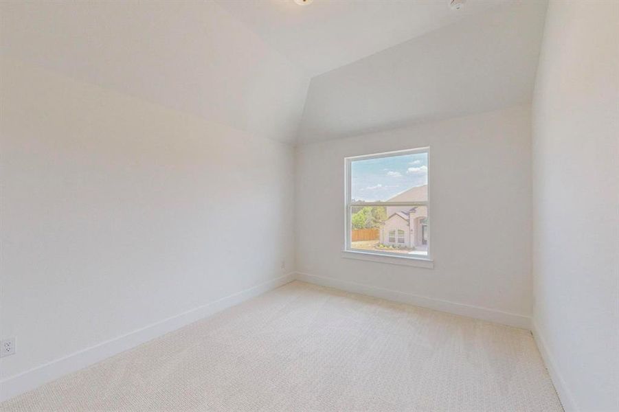 Carpeted empty room with lofted ceiling